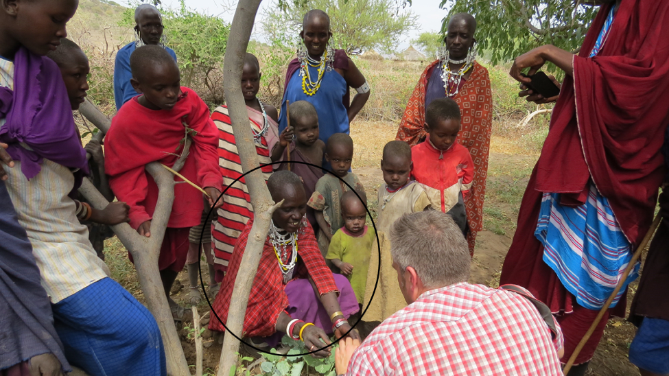 Naitejewoki showing a visitor to Testigo's project the produce in her sack garden.